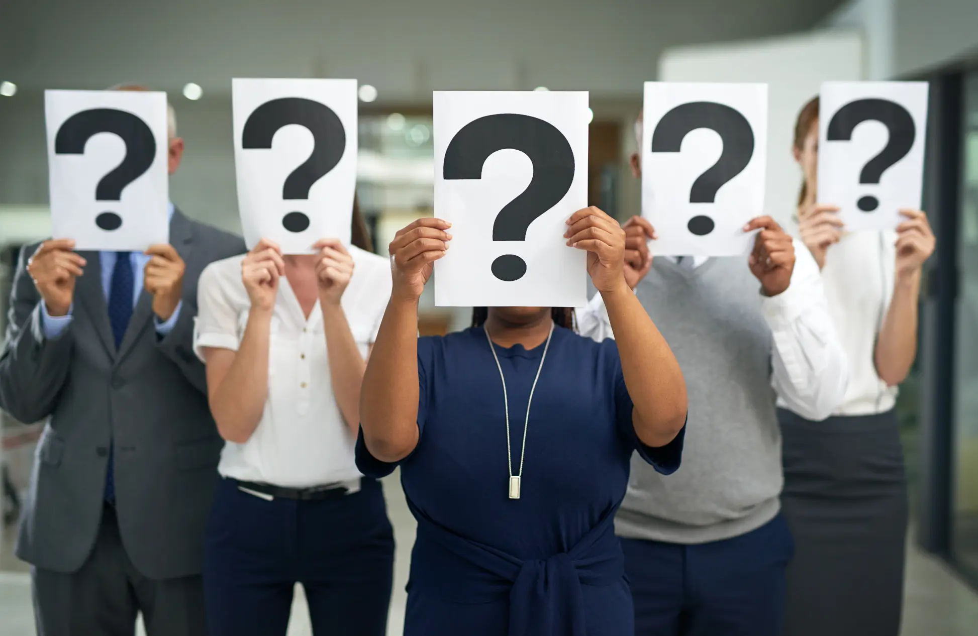 Shot of a group of businesspeople holding question