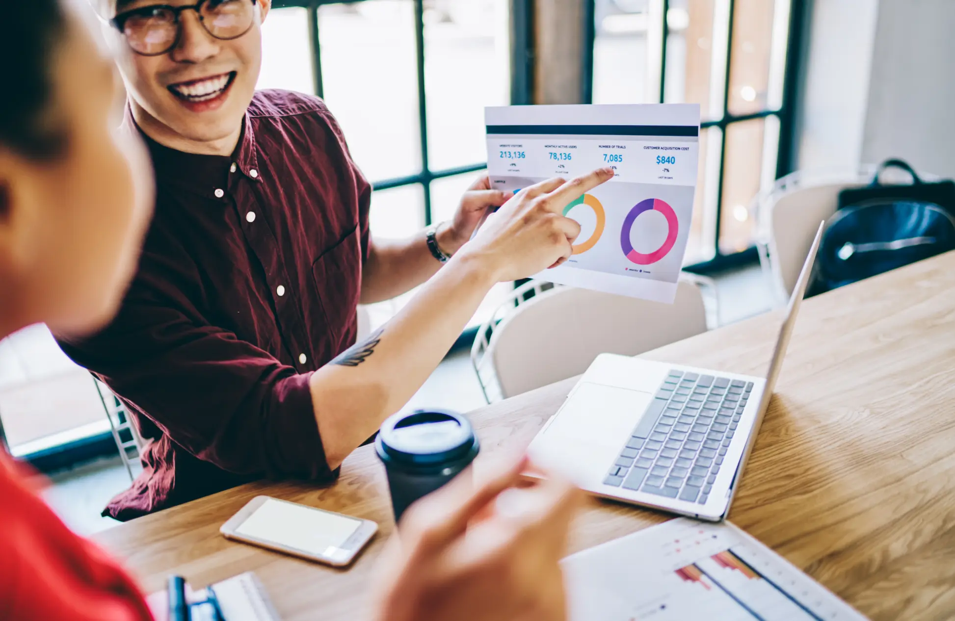 Smiling coworkers checking graph in office